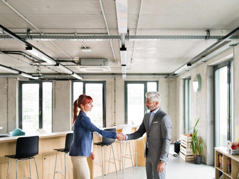 two-business-people-in-the-office-shaking-hands-PWRS4YC.jpg